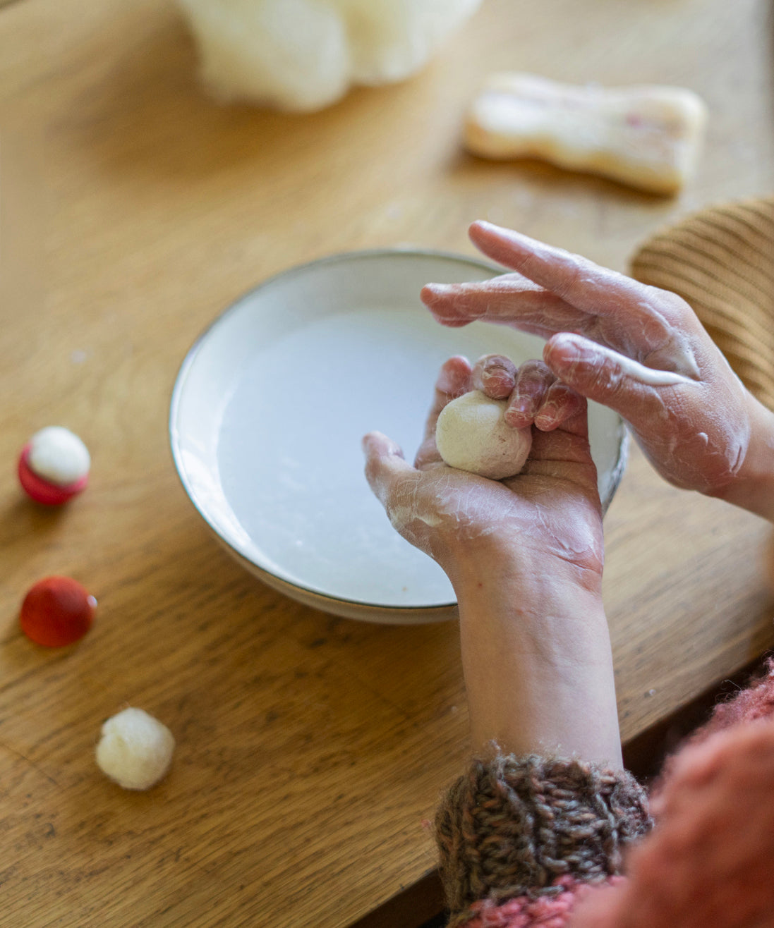 A closer look at the child making a wool ball craft activity, from the Grapat Advent Calendar 2024