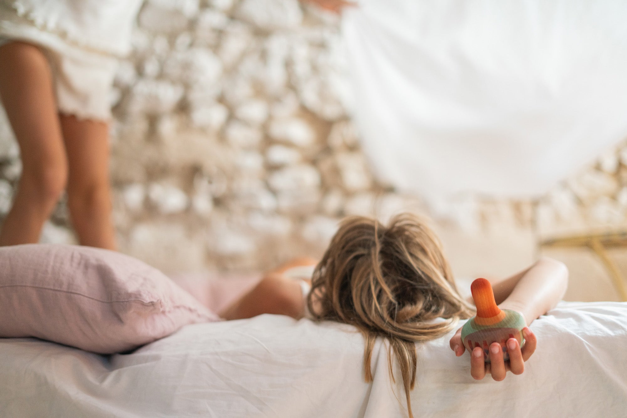 A child holding the Grapat wooden mellow orange bird 