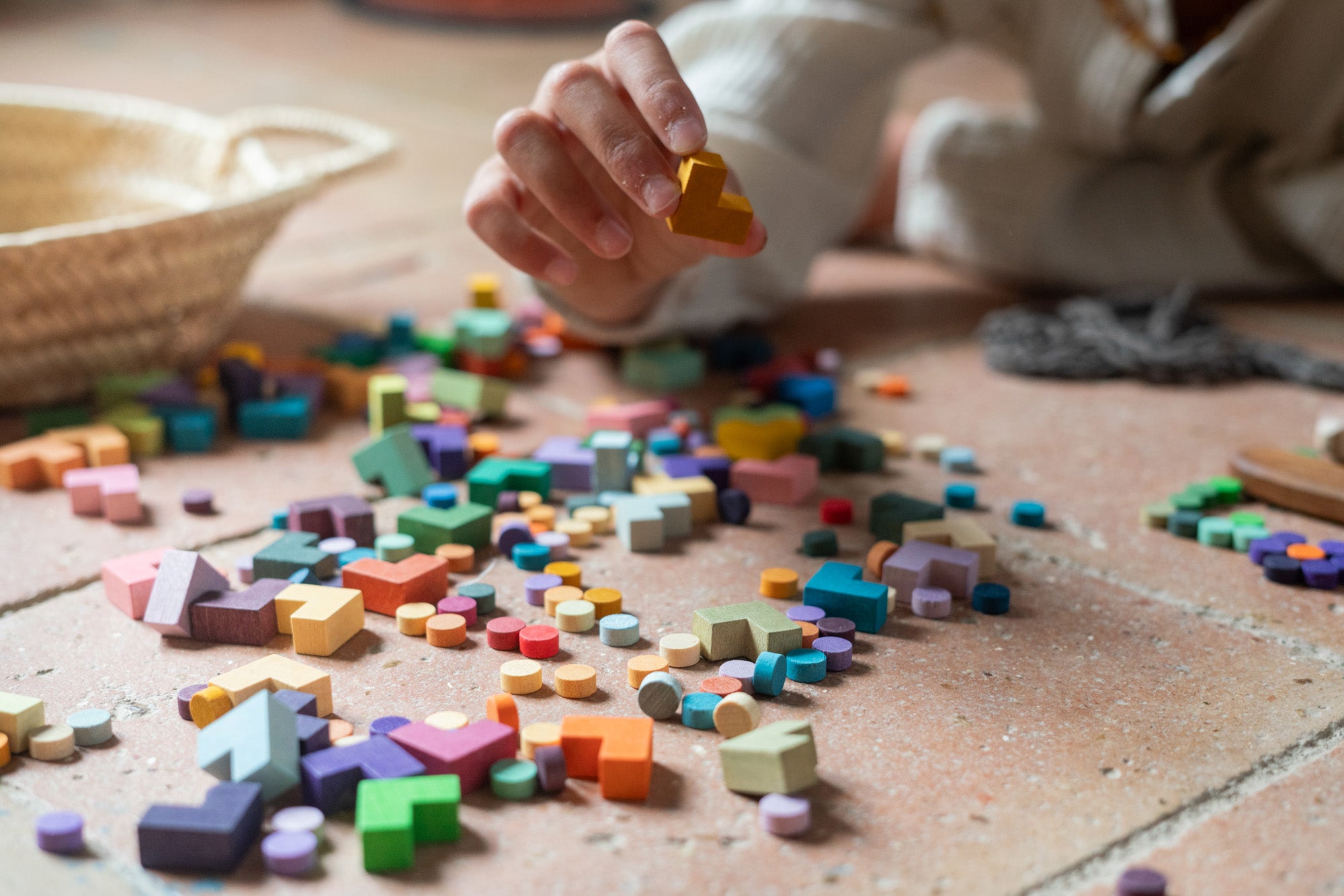 A child holding a yellow block from the Grapat mis and match bloom wooden block set 