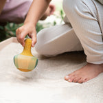 A child playing with the Grapat wooden yellow flowing bird outside in a sandpit bird detail