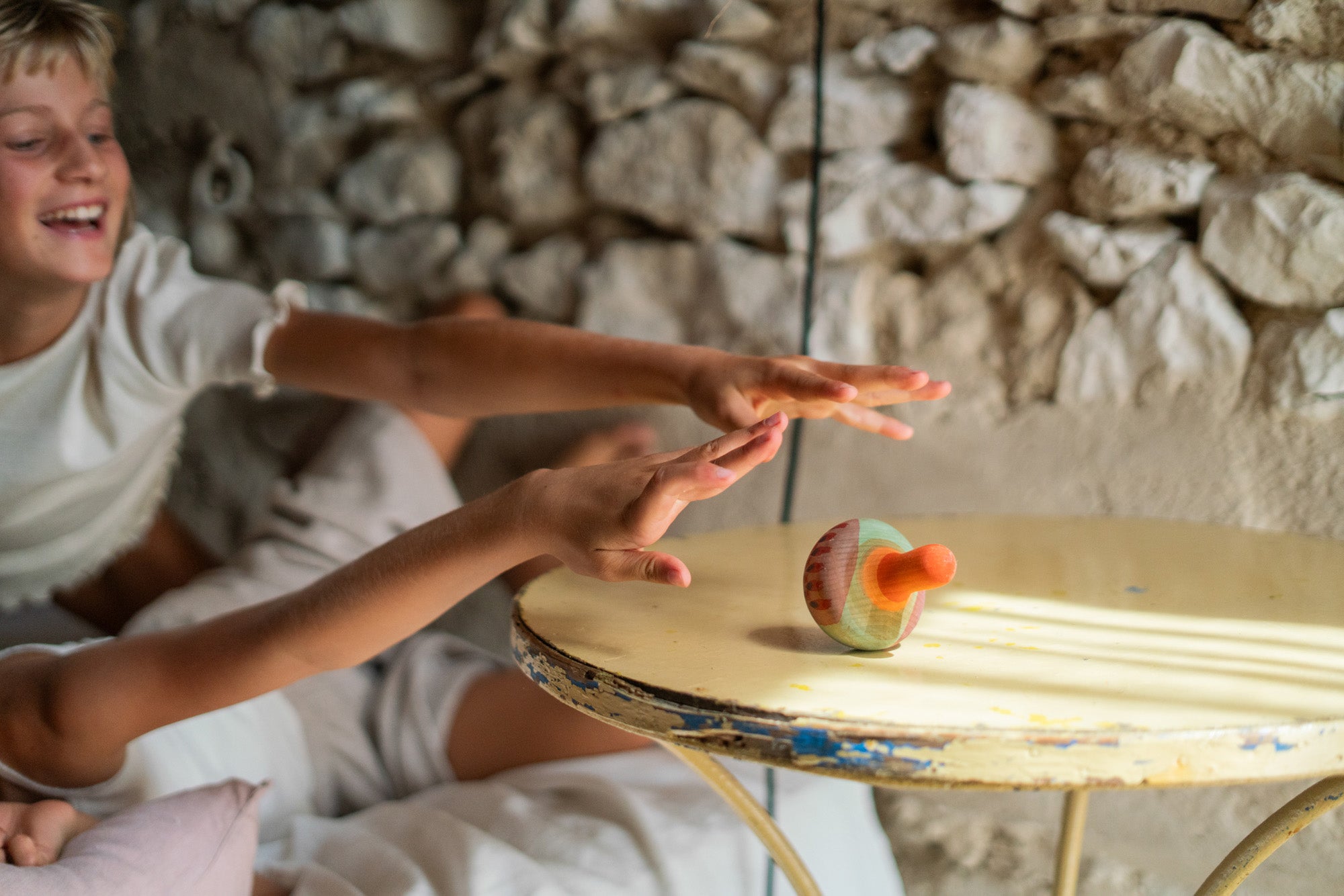 2 children playing with the Grapat wooden mellow orange bird on a table