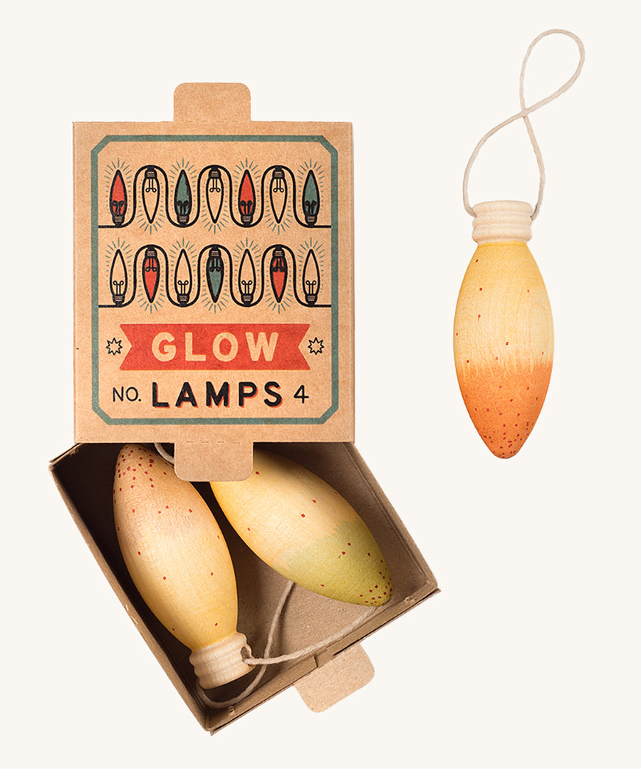 A opened natural cardboard box with the wooden Grapat glow lamps inside on a cream background.