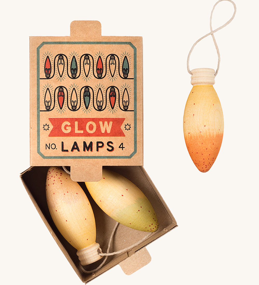 A opened natural cardboard box with the wooden Grapat glow lamps inside on a cream background.