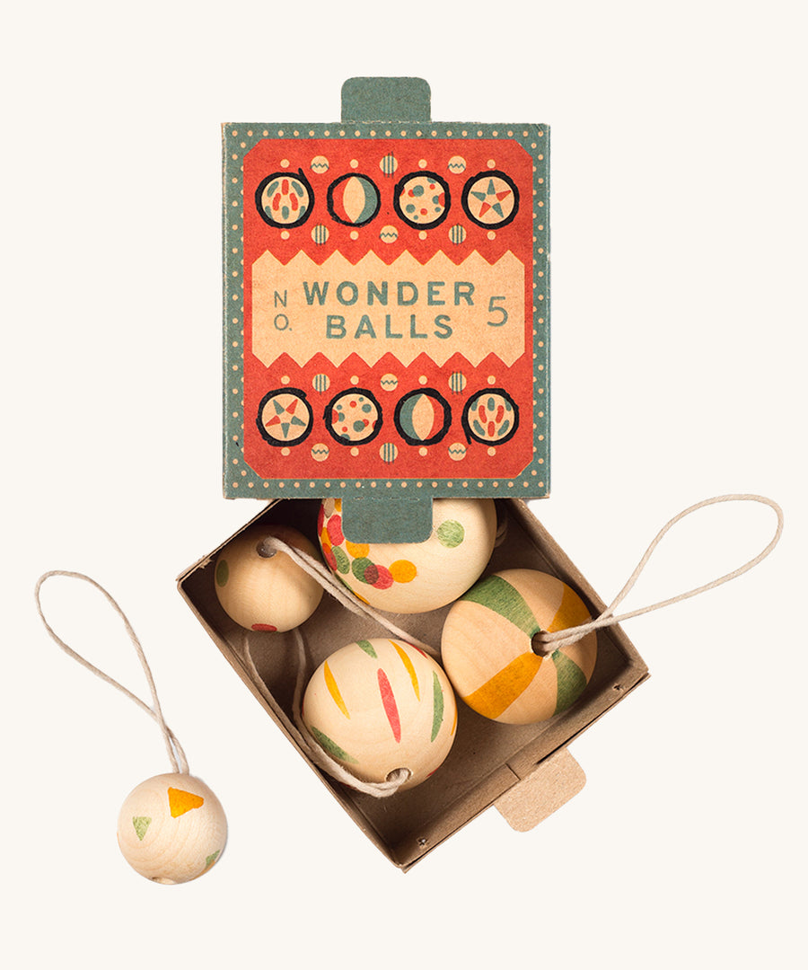 A opened teal and coral cardboard box for the wooden Grapat wonder balls on a cream background