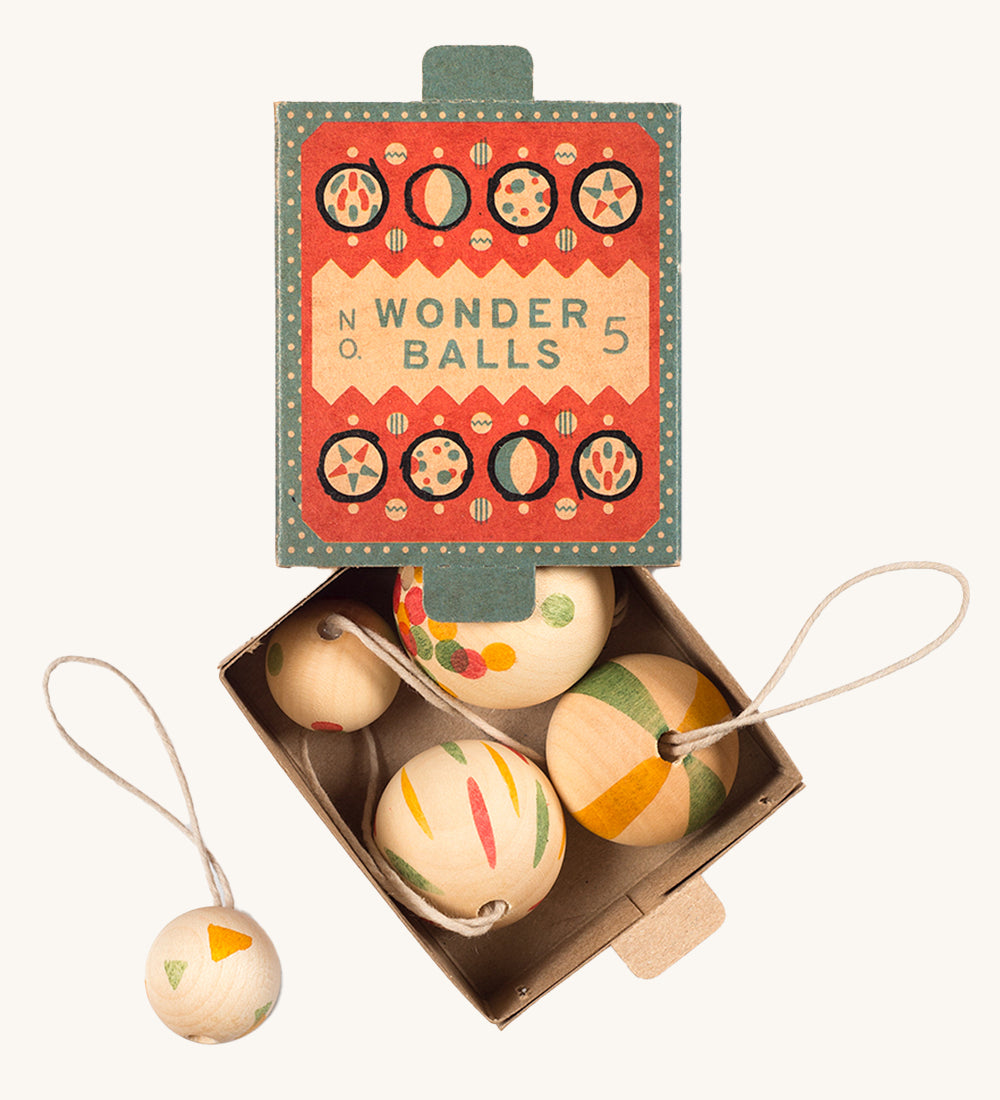 A opened teal and coral cardboard box for the wooden Grapat wonder balls on a cream background