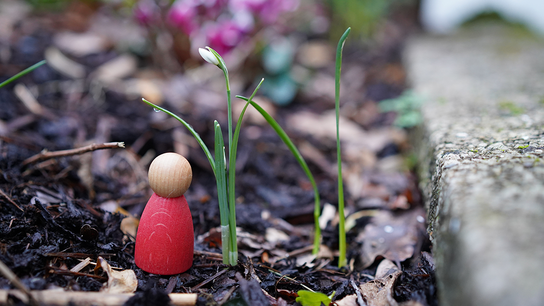 A Grapat wooden toy  Nin in a garden setting