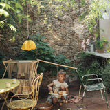 A child playing with the Grapat wooden pendulum set with wooden blocks on the floor outside