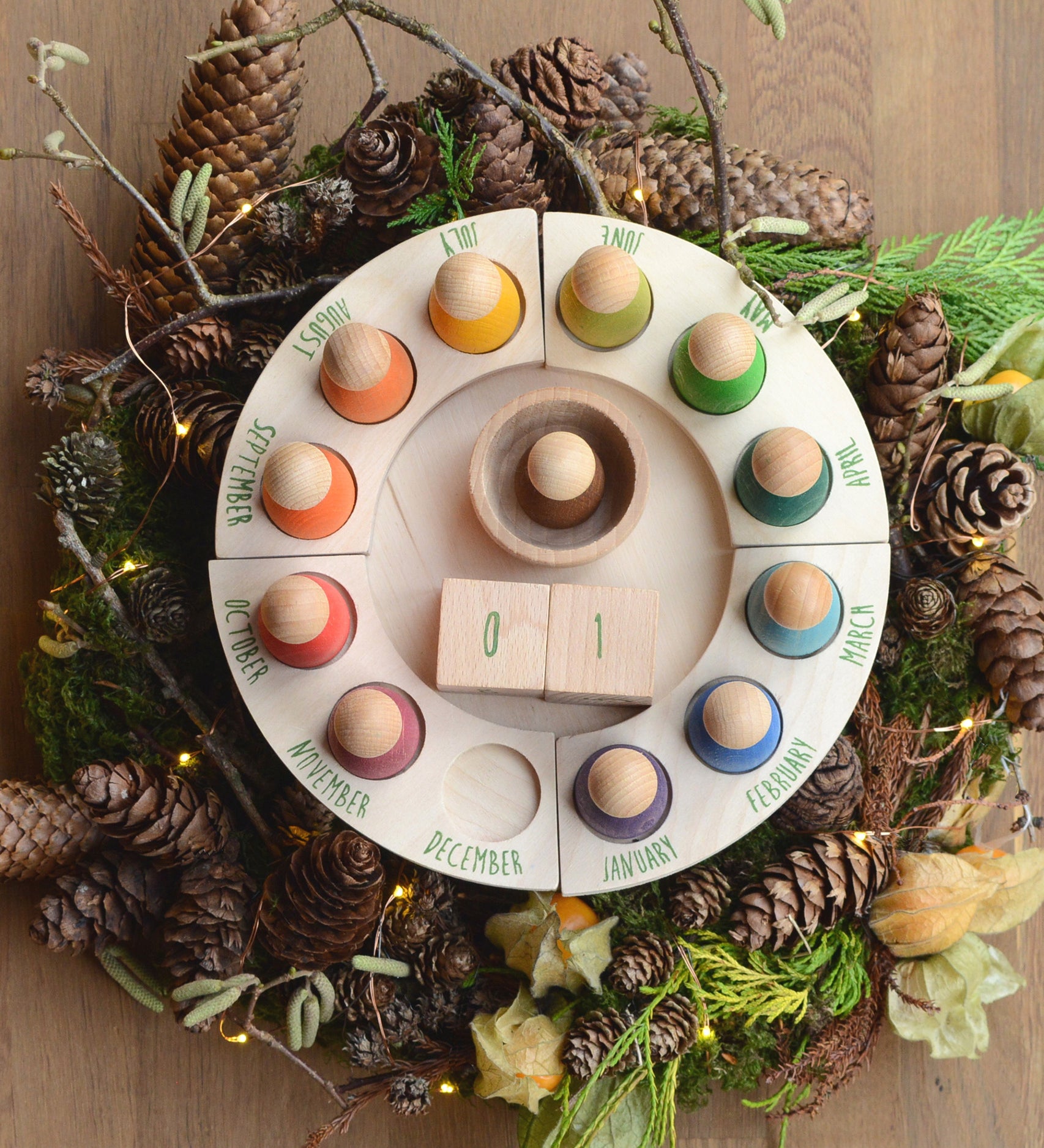 Grapat Perpetual Calendar, a beautiful winter display with a pine-cone wreath surrounding the outside of the calendar.