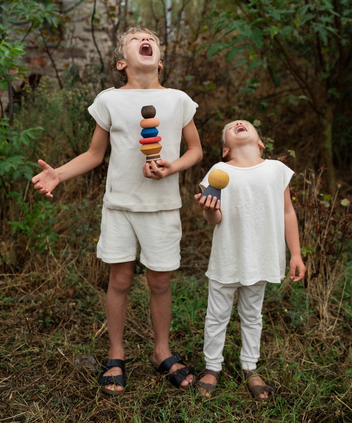 2 children holding the Grapat serendipity stacking set outside