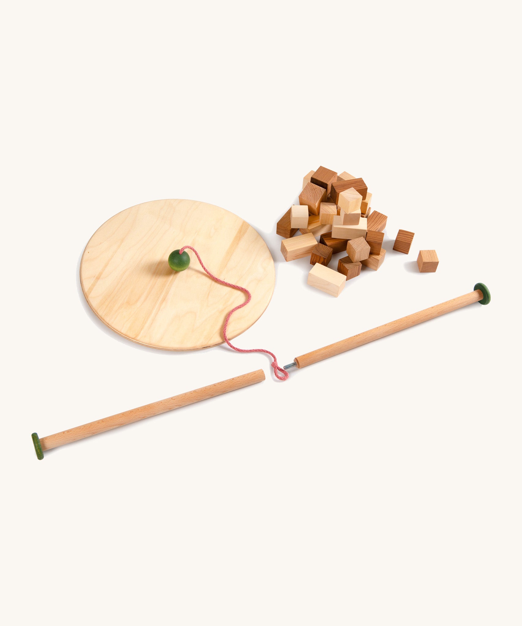 Grapat wooden pendulum set next to wooden blocks on a cream background.