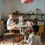 A child playing with the Grapat wooden twin soul puppets by a table