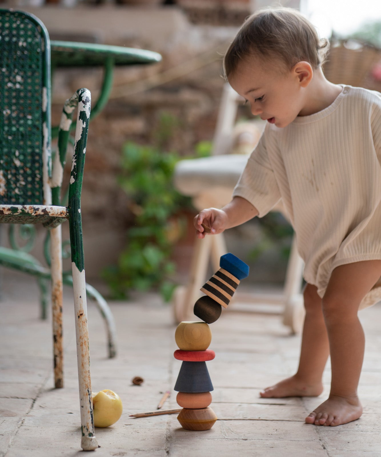 A child playing with the Grapat serendipity stacking set outside on the floor