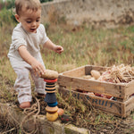 A child playing with the Grapat serendipity stacking set outside on grass