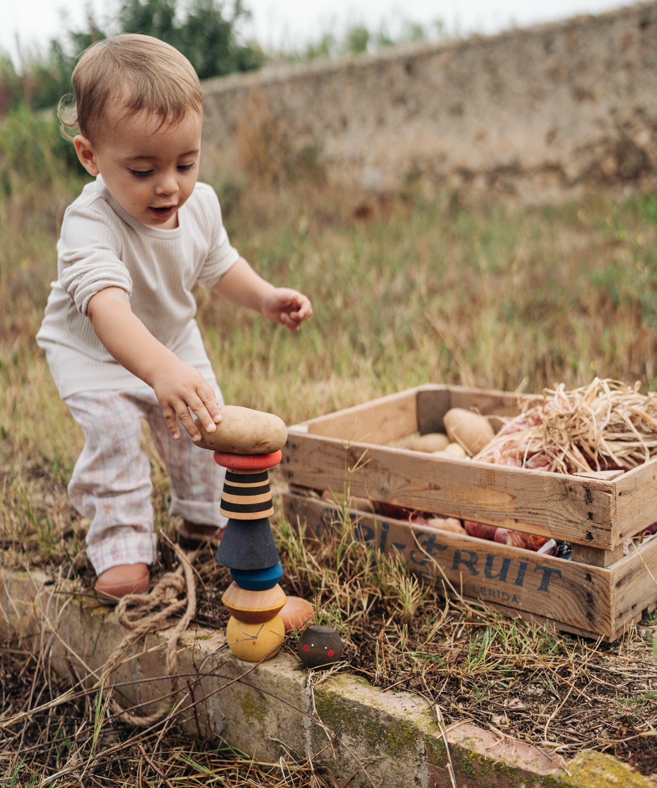 A child playing with the Grapat serendipity stacking set outside on grass