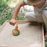 A child playing with the Grapat wooden yellow flowing bird outside bird detail