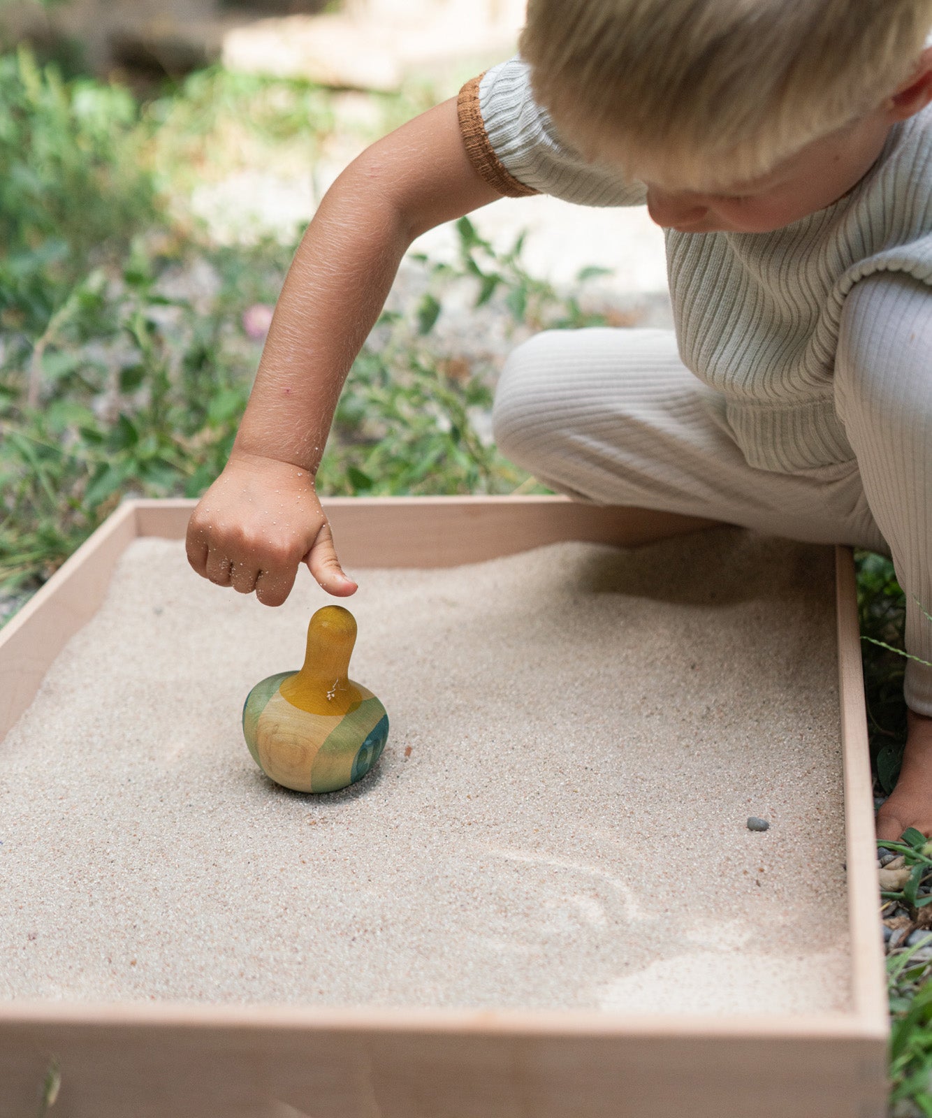 A child playing with the Grapat wooden yellow flowing bird outside bird detail