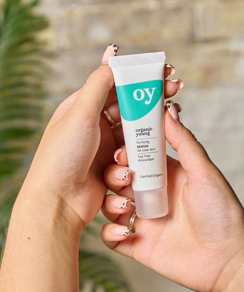 A person holding the Green People OY! Organic Teen Purifying Serum - 30ml in their hands, showing the front of the tube