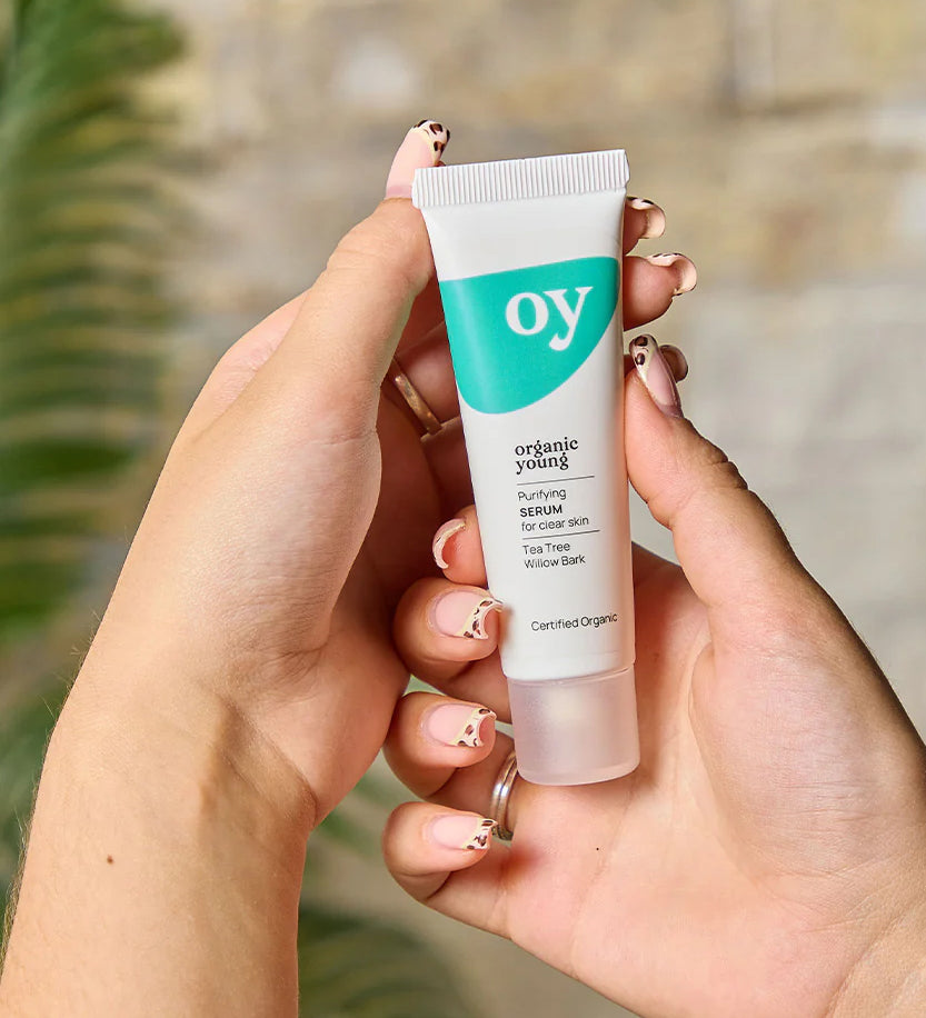 A person holding the Green People OY! Organic Teen Purifying Serum - 30ml in their hands, showing the front of the tube