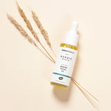 The Green People Nordic Roots Marine Facial Oil - bottle on a beige background and laid on top of dried grass