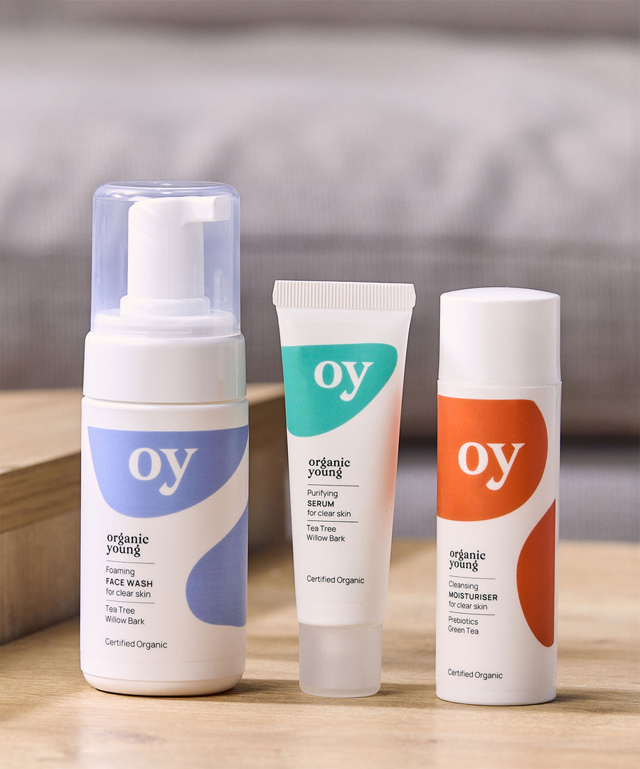 The OY organic, teen and tween skin care gift set with tee tree face wash, purifying serum and cleansing moisturiser which are sat on a wooden table with a grey background