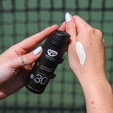 A person has spread some of the Green People Sports SPF30 Mineral Sun Cream 50ml onto their hand to show the colour of the cream