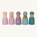 Grimm's 5 Maths Friends wooden pastel peg dolls each with a mathematical symbol painted on the front. From left to right is an addition sign, a subtraction sign, an equals sign, a multiplication sign and two dots as a divide sign, on a cream background.