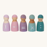 Grimm's 5 Maths Friends wooden pastel peg dolls each with a mathematical symbol painted on the front. From left to right is an addition sign, a subtraction sign, an equals sign, a multiplication sign and two dots as a divide sign, on a cream background.