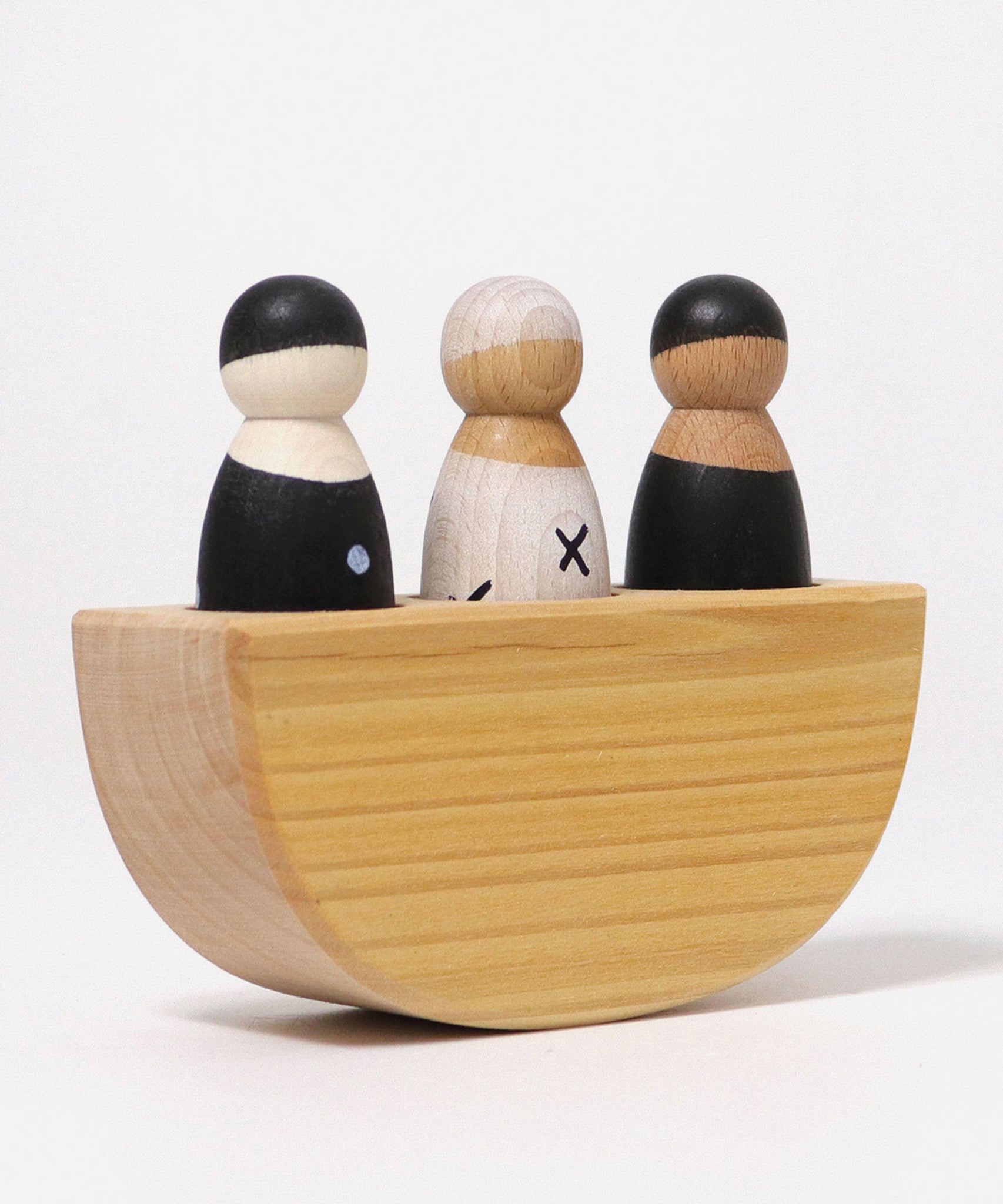 A angular view of the Grimm's 3 in a Boat Monochrome, showing the thickness of the natural wooden boat and the three peg dolls sat inside