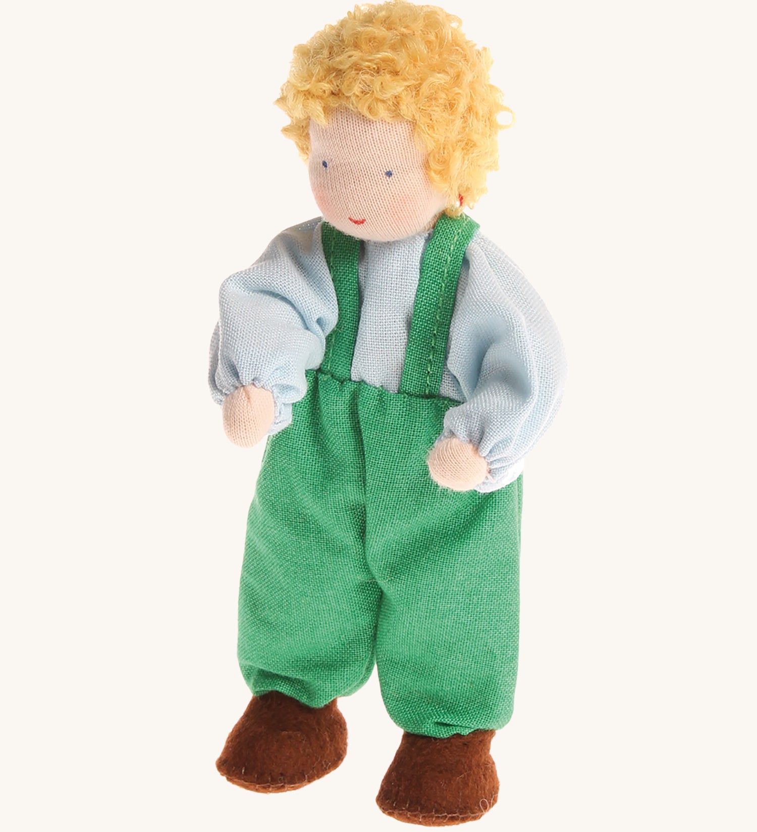 Grimm's Blond Boy Doll - Linde is a Waldorf inspired, soft body, handmade, fabric toy doll with blonde hair, a light blue top, green dungarees and brown shoes, on a cream, background