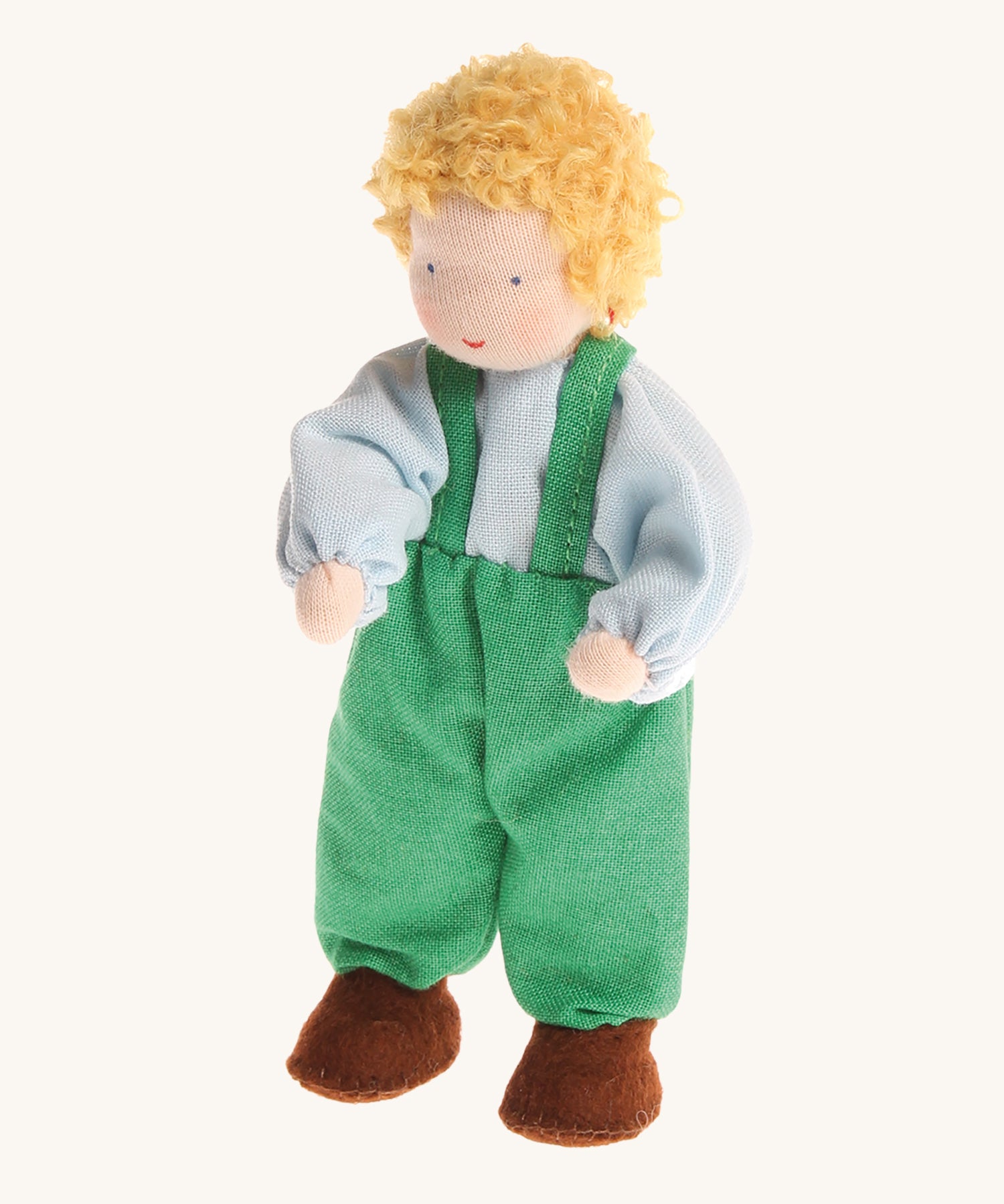 Grimm's Blond Boy Doll - Linde is a Waldorf inspired, soft body, handmade, fabric toy doll with blonde hair, a light blue top, green dungarees and brown shoes, on a cream, background