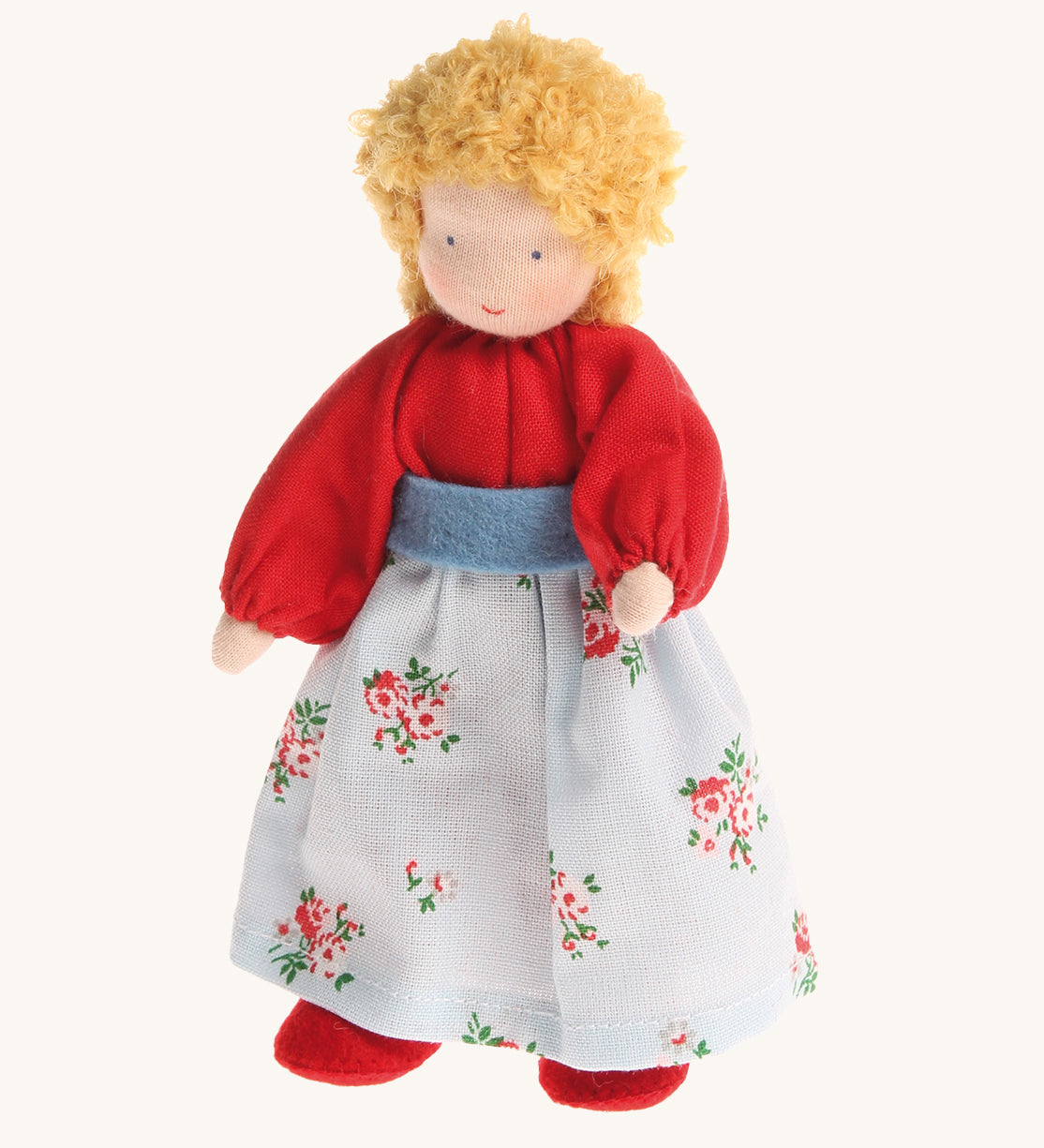 Grimm's Blonde Woman Doll, is a soft body, Waldorf inspired, handmade, fabric toy with blonde hair, a red top, a floral pattern skirt and red shoes. The image is on a cream background