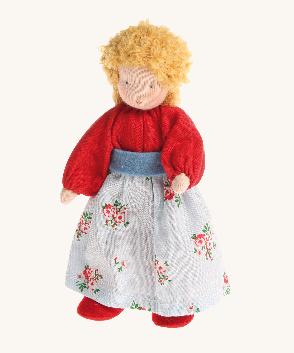 Grimm's Blonde Woman Doll, is a soft body, Waldorf inspired, handmade, fabric toy with blonde hair, a red top, a floral pattern skirt and red shoes. The image is on a cream background