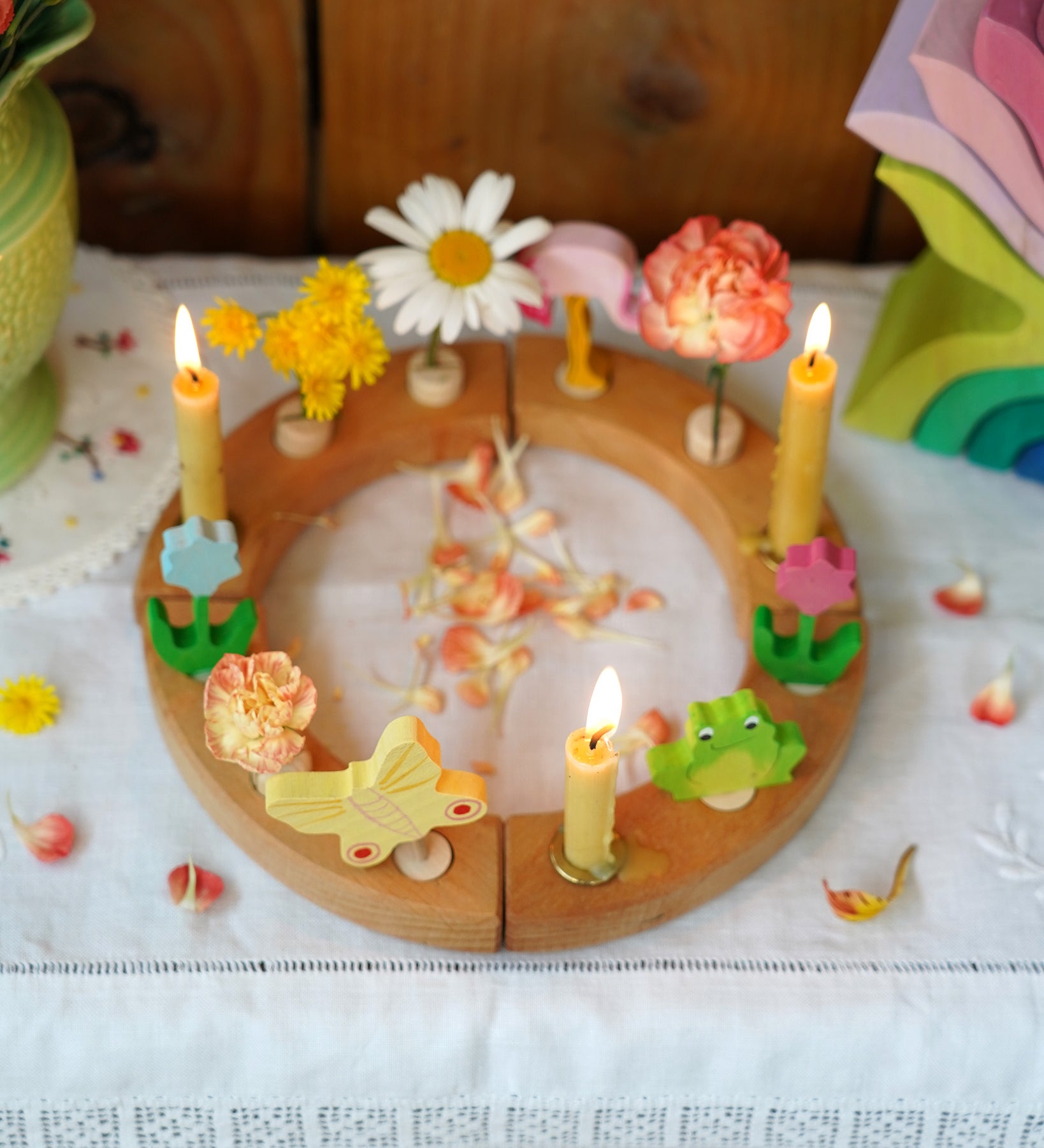 A beautiful Grimm's Celebration Ring with cream coloured Grimm's candles in candle holders, along with pretty Grimm's decorative figures make up a wonderful Sprint time display