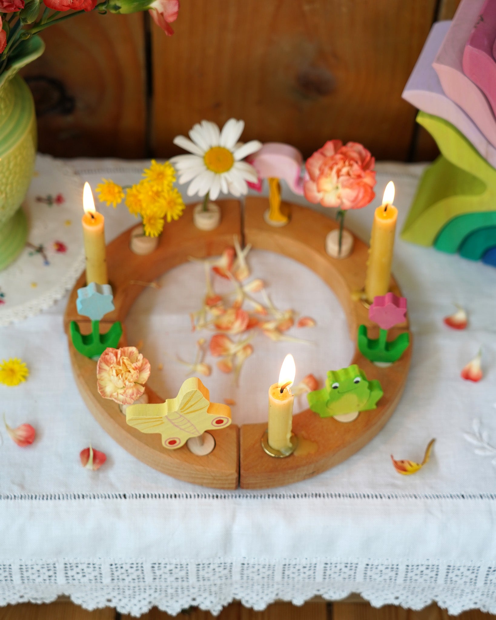 A beautiful Grimm's Celebration Ring with cream coloured Grimm's candles in candle holders, along with pretty Grimm's decorative figures make up a wonderful Sprint time display