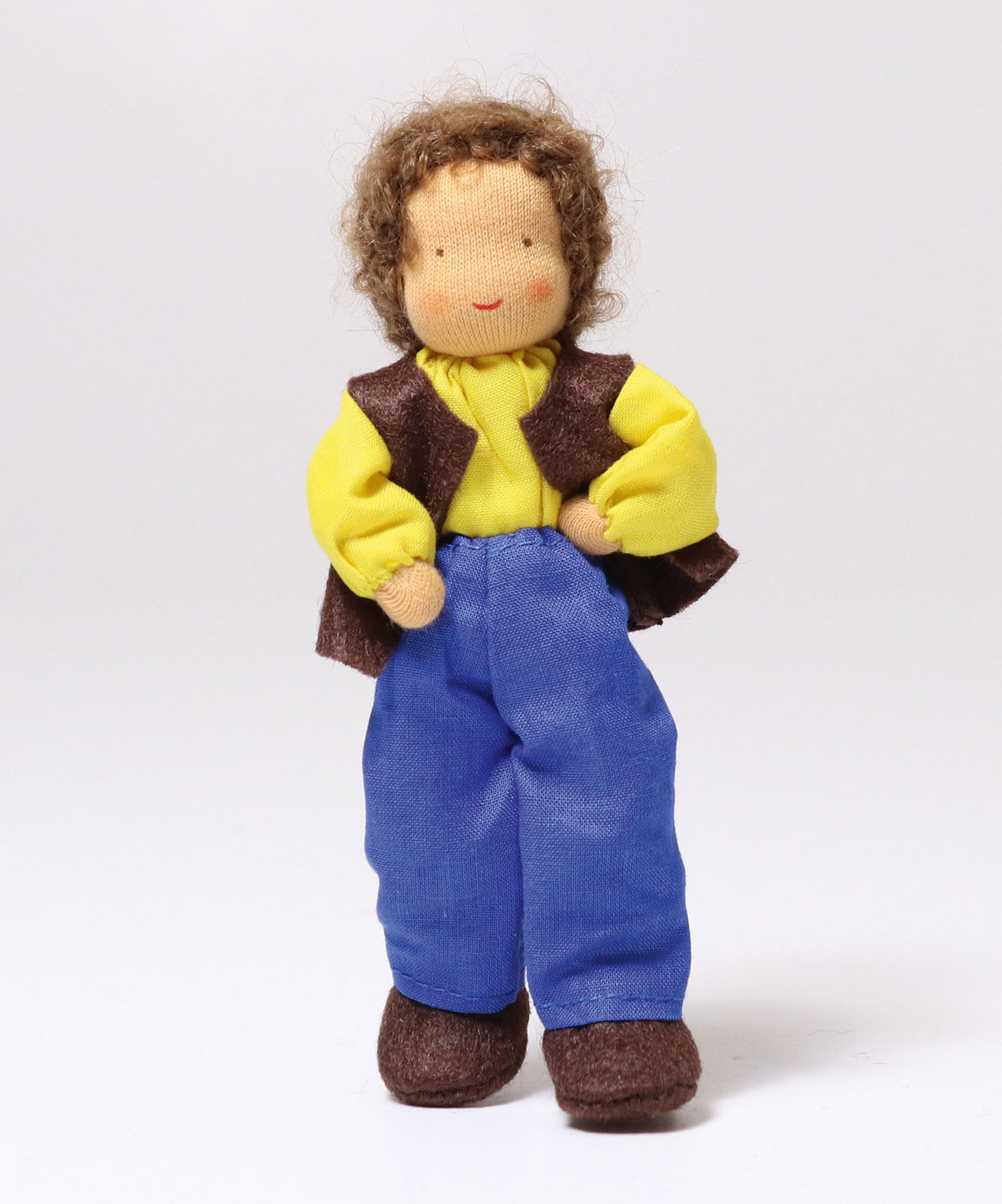 Grimm's Brown Haired Man Doll - Erle standing up with its hands on its hips and one leg forward, showing how little ones can move the arms and legs with ease