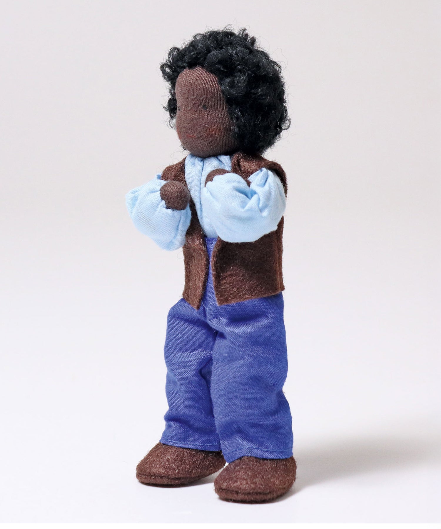 Grimm's Handmade Doll - Mr Ebony is stood up with its arms bent towards its face at the elbows, showing off the flexibility of the doll. The image is on a light grey background