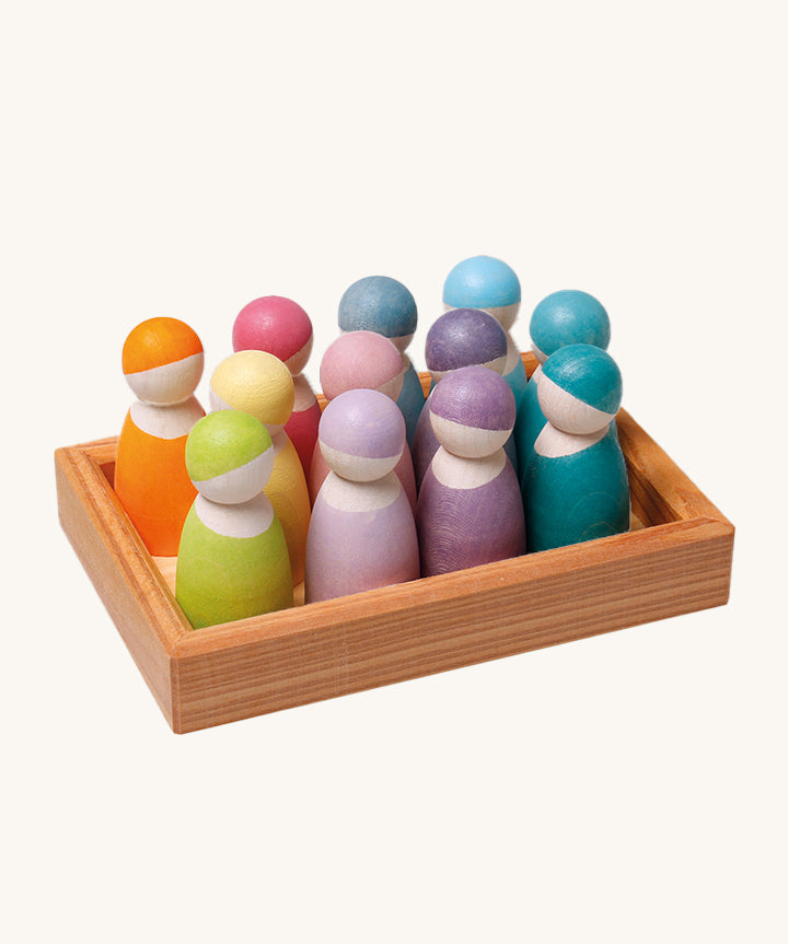 The Grimm's 12 Pastel Friends together in a small wooden tray on a cream background