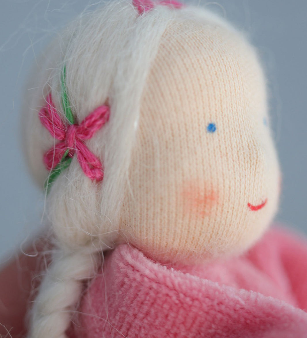 A closer look at the hair on the Grimm's Pink Lavender Girl showing pink embroidered bows with green vines