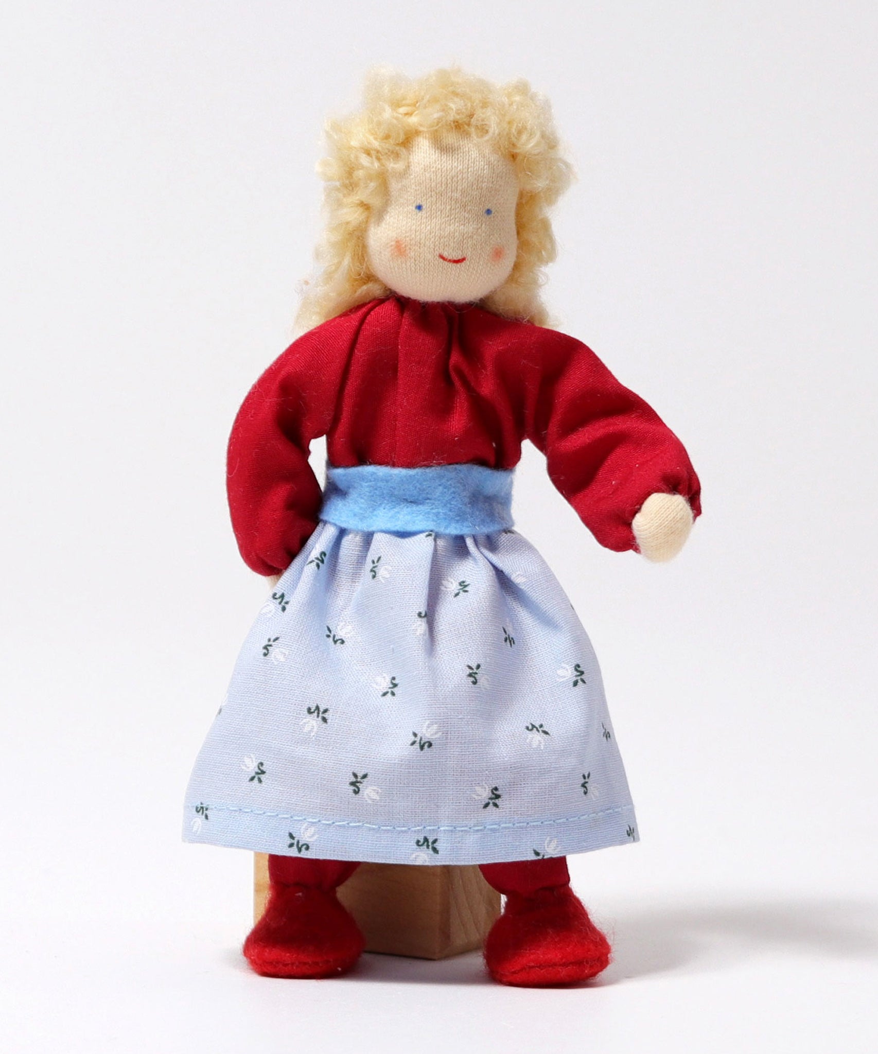 Grimm's Blonde Woman Doll is stood in front of a wooden block of wood, showing how the doll can balance on its feet