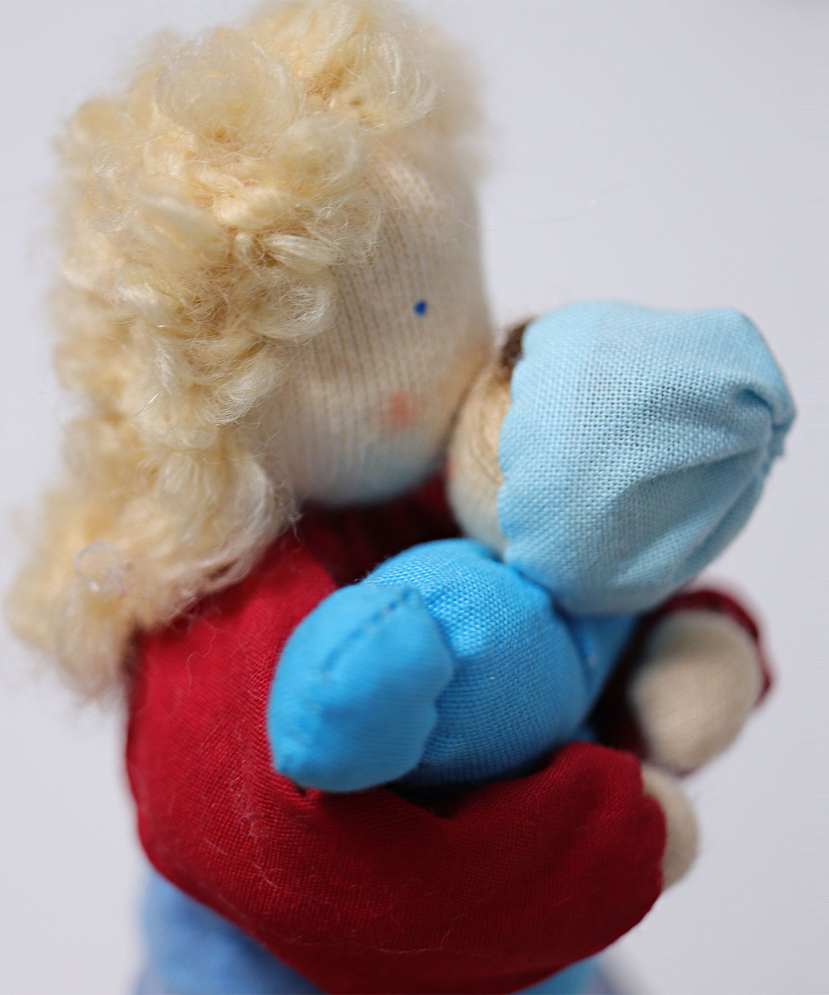 Grimm's Blonde Woman Doll is holding a small Grimm's doll to its chest, showing how the dolls can interact with each other and how they can be played with