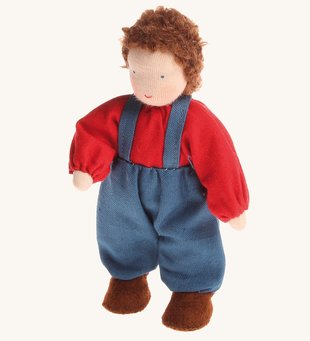 Grimm's Brown Haired Boy Doll - Peter. Peter has brown hair and is wearing a red top with blue trousers and braces, on a cream background