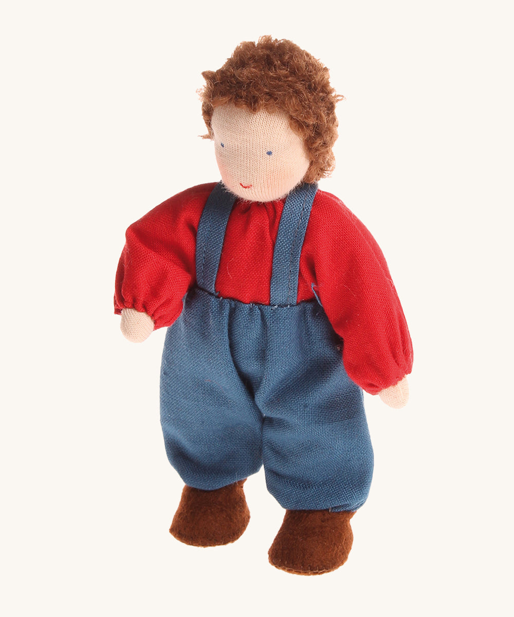 Grimm's Brown Haired Boy Doll - Peter. Peter has brown hair and is wearing a red top with blue trousers and braces, on a cream background