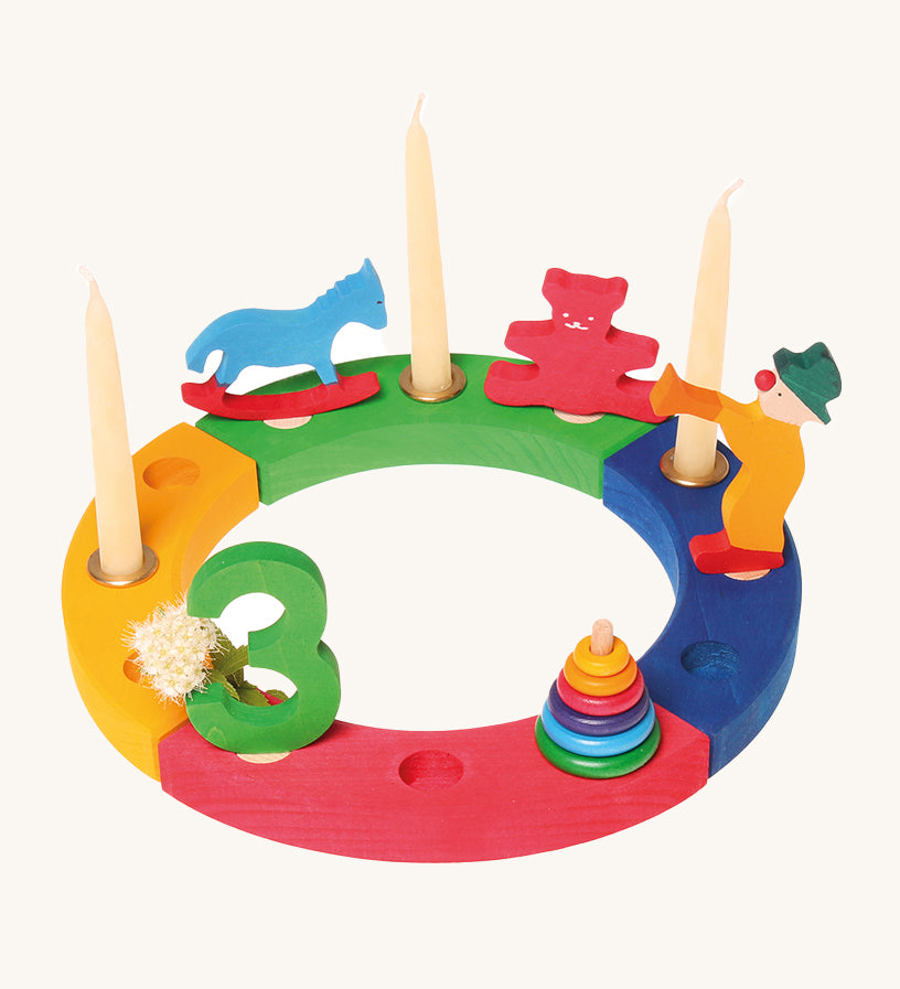 The Grimm's 12-Hole Coloured Wooden Ring with Grimm's decorative figures and candles, celebrating a third birthday