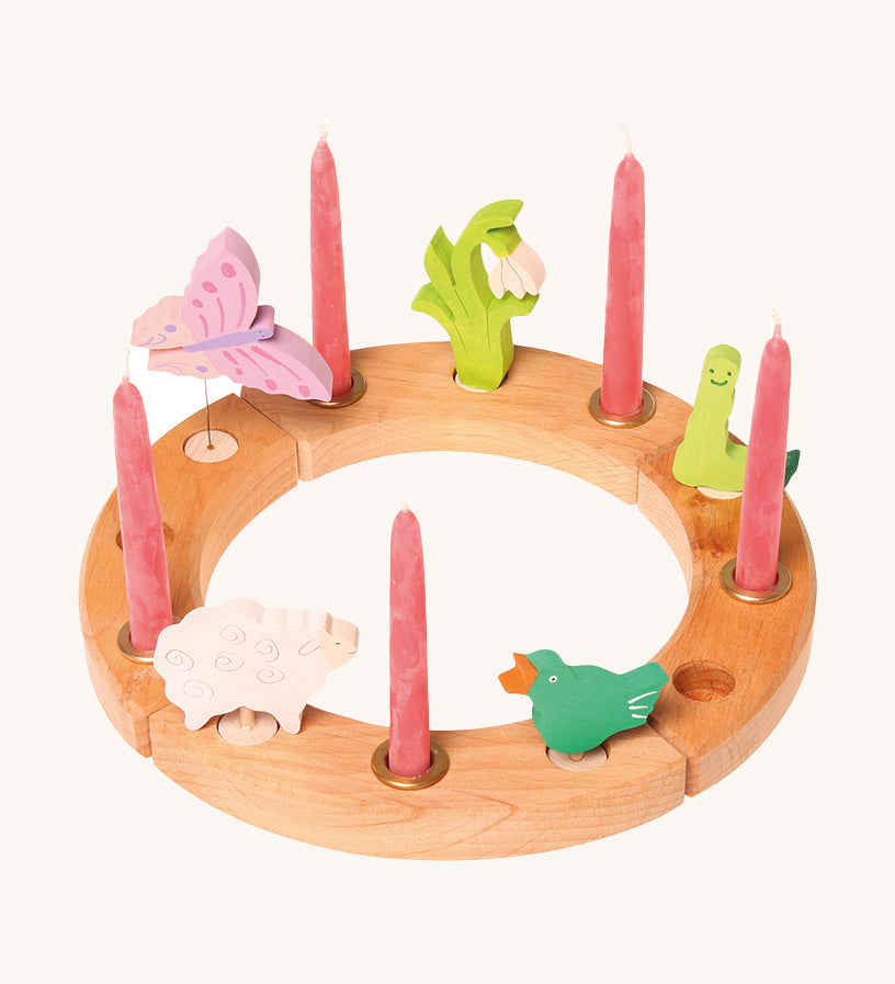 Grimm's 12-Hole Natural Wooden Celebration Ring with pink candles and springtime decorative figures, on a cream background