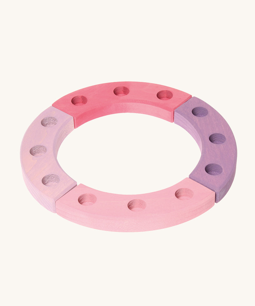 Grimm's 12-Hole Pink-Purple Wooden Celebration Ring on a cream background