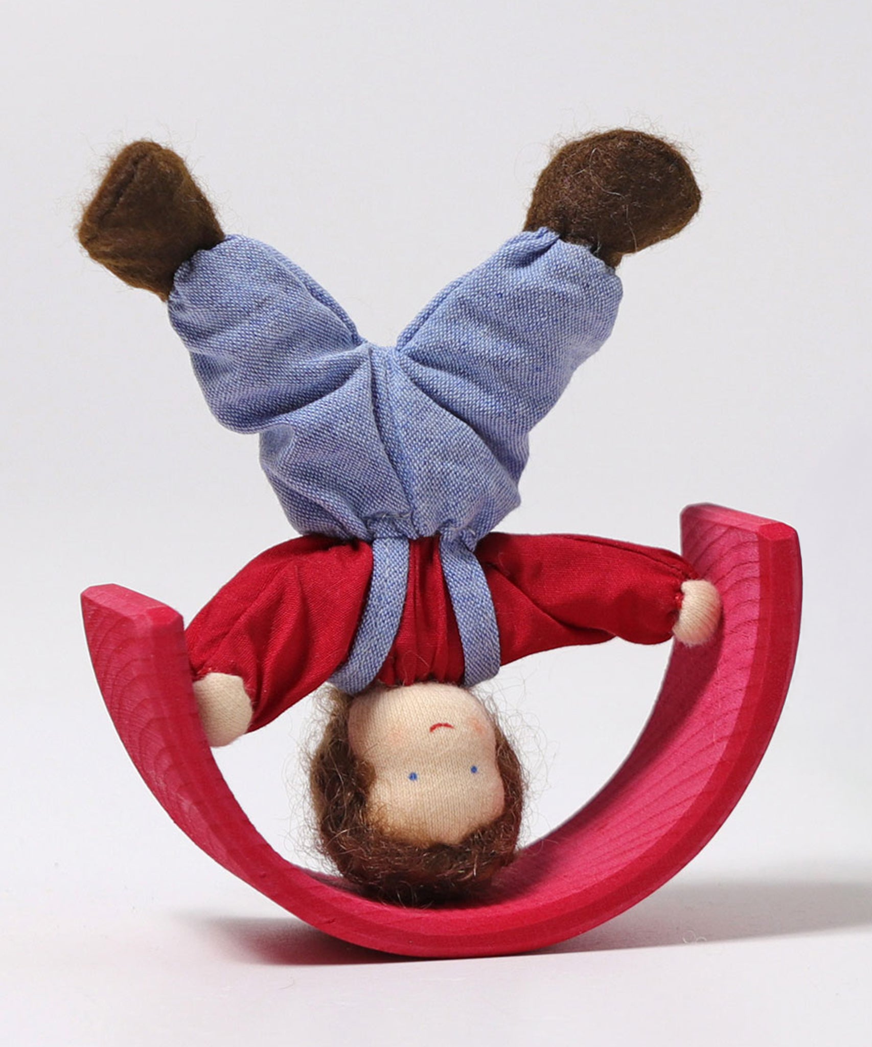 Grimm's Brown Haired Doll - Peter is doing a handstand on a red piece of a Grimm's wooden rainbow. Peter is upside down and the rainbow piece is resting on the top of its arch like a sea-saw