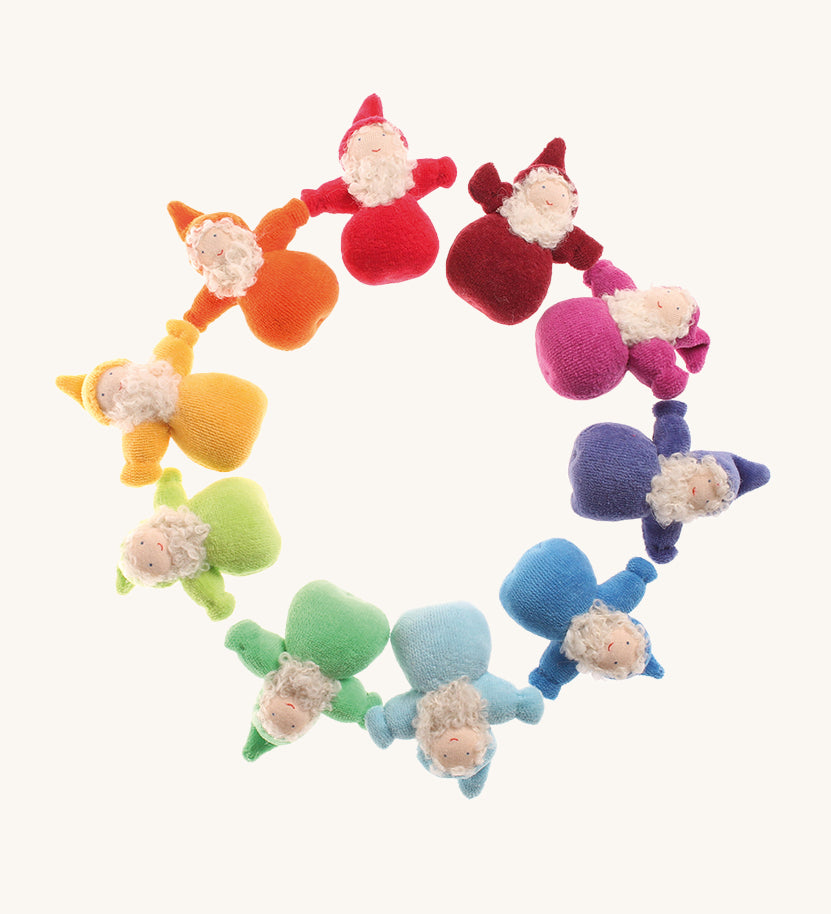 Grimm's Bearded Dwarfs in a circle. These fabric, handmade, waldorf, toy dolls, are one colour of the rainbow in red, orange, yellow, light green, teal, light blue, blue, indigo, pink and magenta. The image is on a cream background