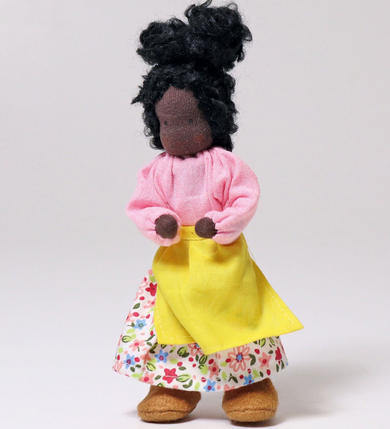 Grimm's Handmade Doll - Mrs Ebony is stood upright with its arm bent at the elbows towards its middle. The image is on a light grey background