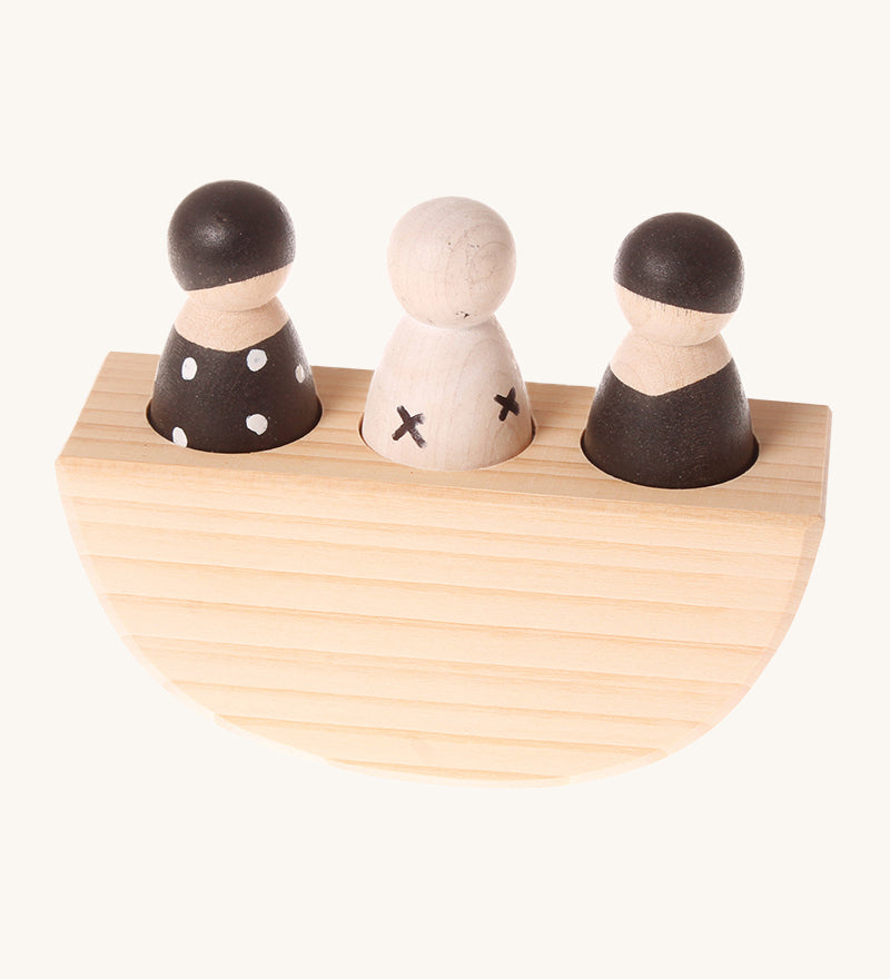 Grimm's 3 in a Boat Monochrome is a fun wooden Waldorf toy which includes three wooden peg dolls in black and white monochrome print sat in side a wooden curved based boat which rocks side to side. The image is on a cream background