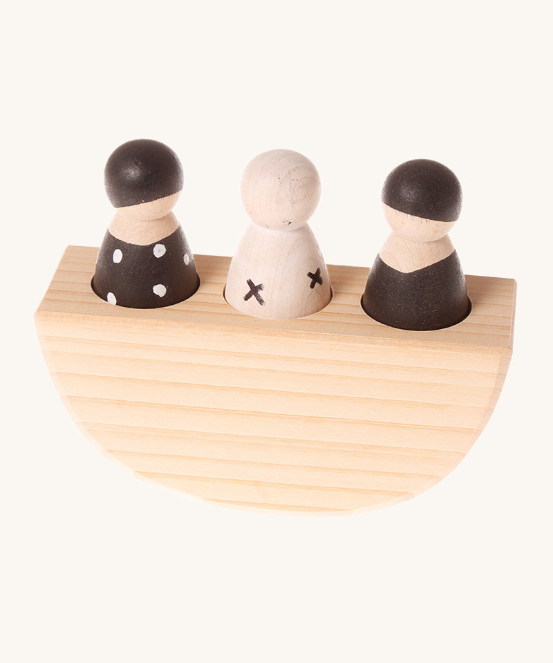 Grimm's 3 in a Boat Monochrome is a fun wooden Waldorf toy which includes three wooden peg dolls in black and white monochrome print sat in side a wooden curved based boat which rocks side to side. The image is on a cream background